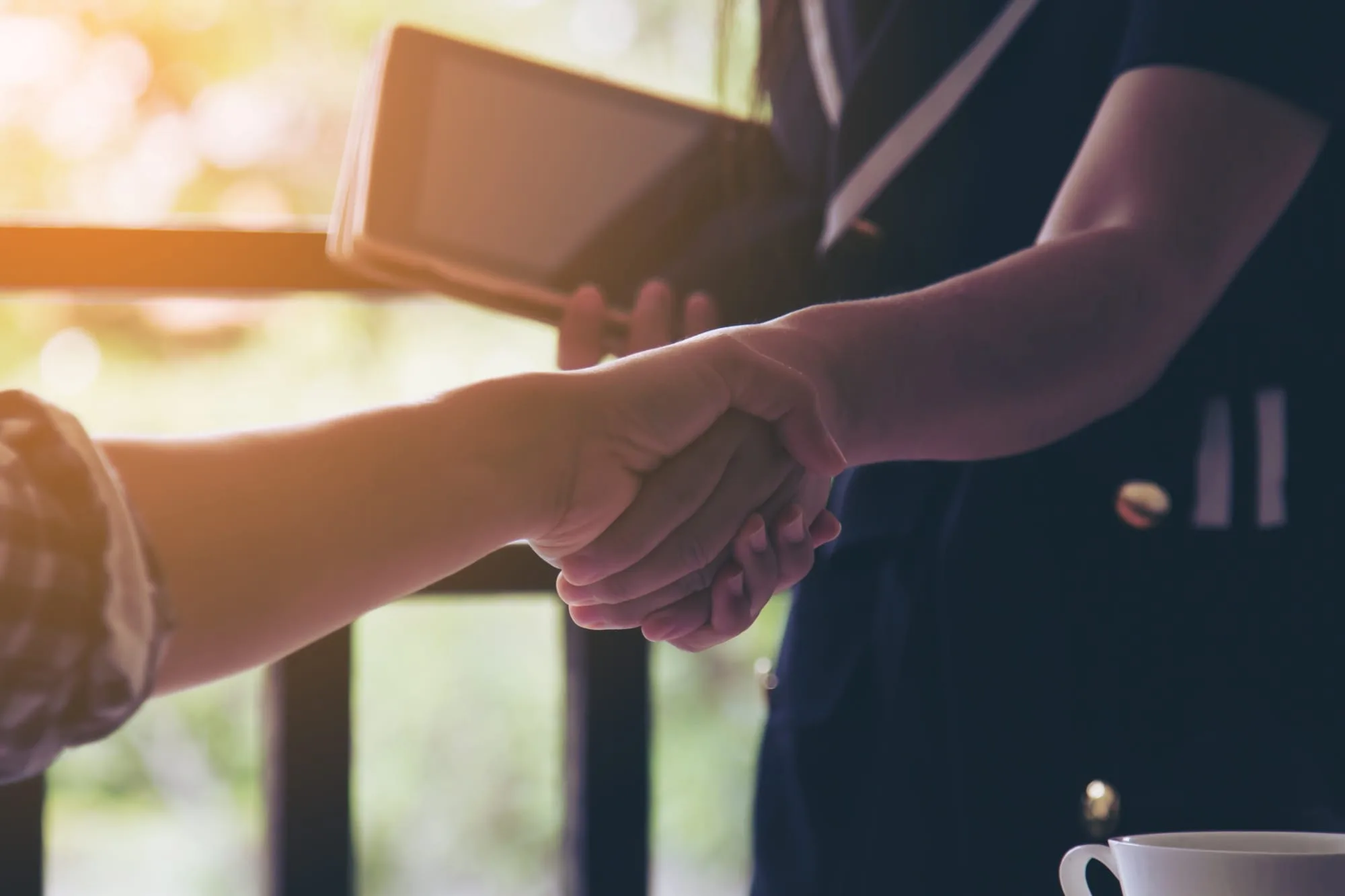 Une poignée de main entre 2 femmes, l'une d'elle Mathilde la Ruche administrative et l'autre est une entrepreneuse, cliente de la Ruche administrative. Assistante virtuelle